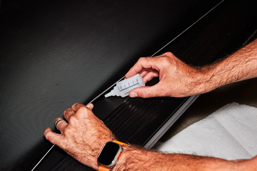 Treadmill maintenance showing belt lubrication, crucial for both AC vs DC treadmill motors longevity.